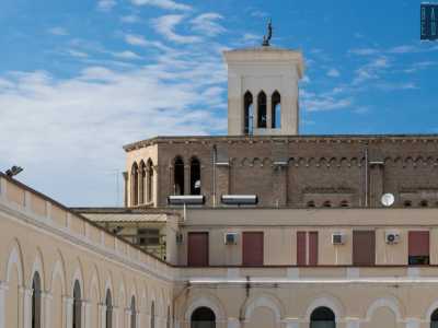In fondo notiamo il campanile della chiesa che spicca verso il cielo adornato da una statuetta raffigurante il Redentore